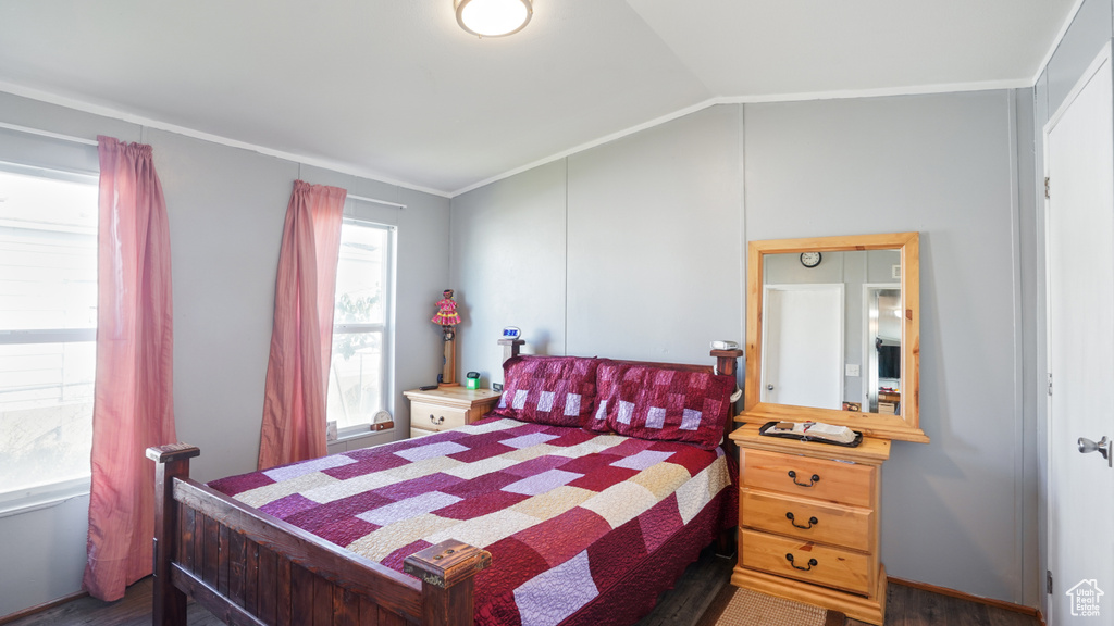 Bedroom featuring ornamental molding, dark hardwood / wood-style floors, and lofted ceiling