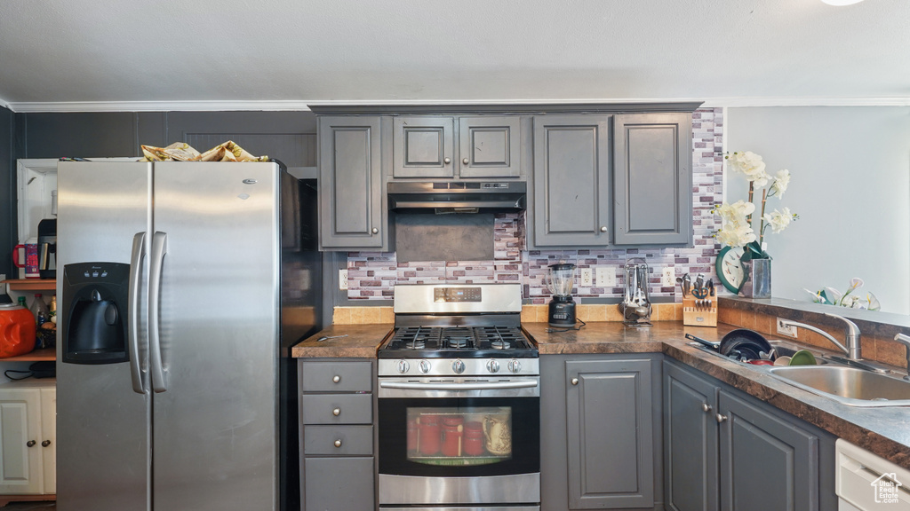 Kitchen featuring sink, stainless steel appliances, tasteful backsplash, and gray cabinets
