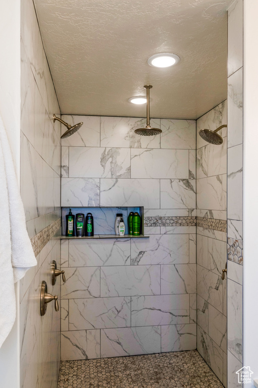 Bathroom with a tile shower and a textured ceiling
