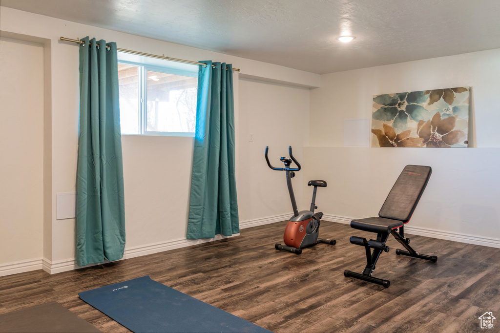 Workout room with dark wood-type flooring