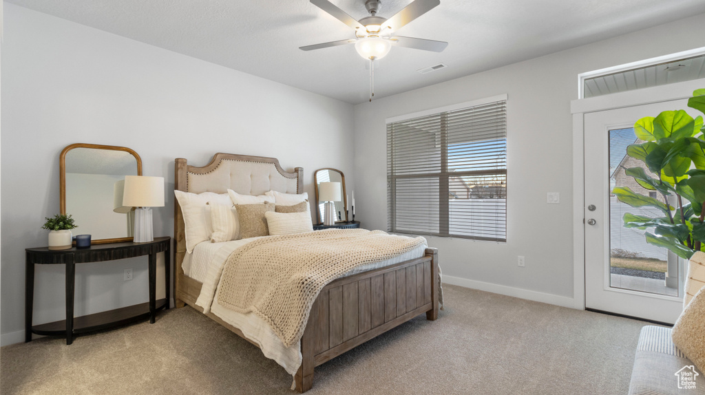 Bedroom featuring access to exterior, ceiling fan, and light carpet