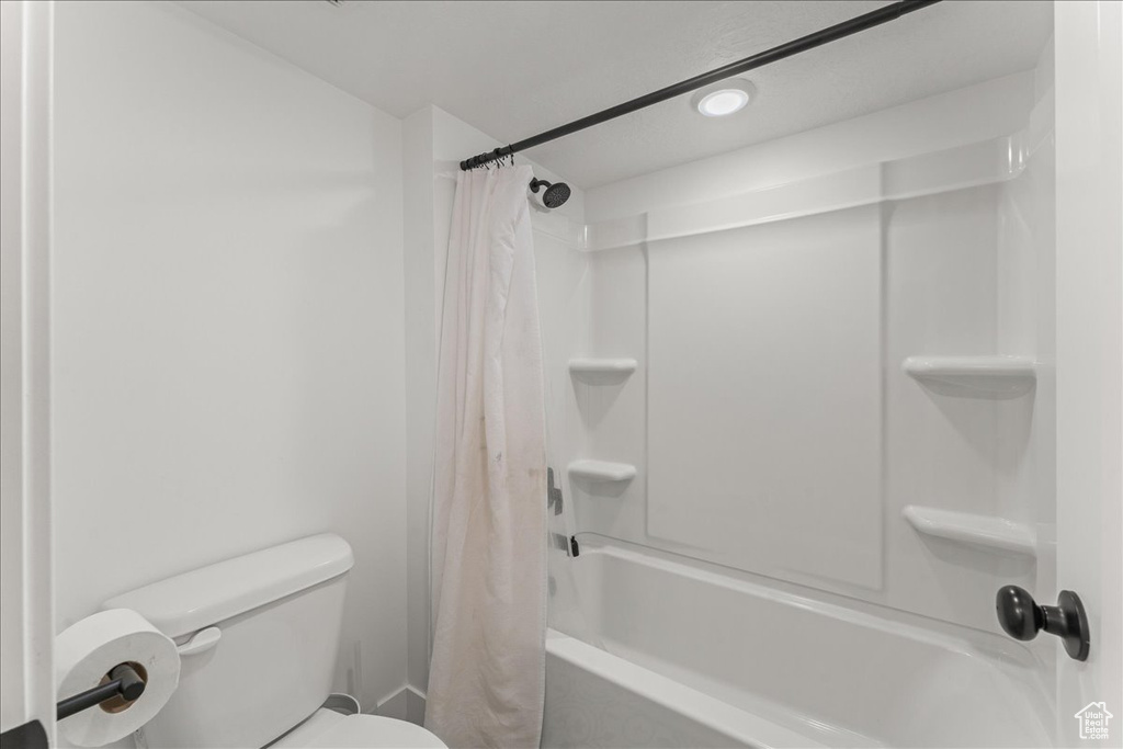 Bathroom featuring shower / tub combo with curtain and toilet