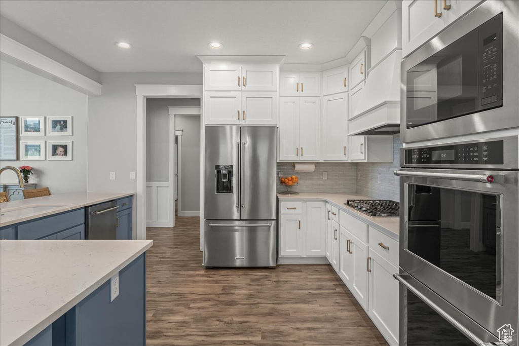 Kitchen featuring dark hardwood / wood-style floors, white cabinets, sink, and appliances with stainless steel finishes