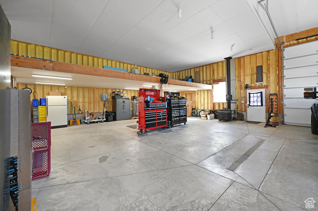 Garage featuring white refrigerator and a workshop area