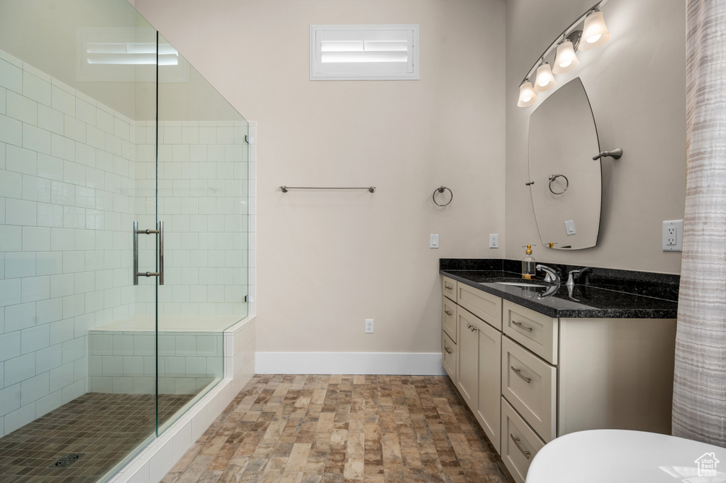 Bathroom with a shower with door, tile flooring, and oversized vanity