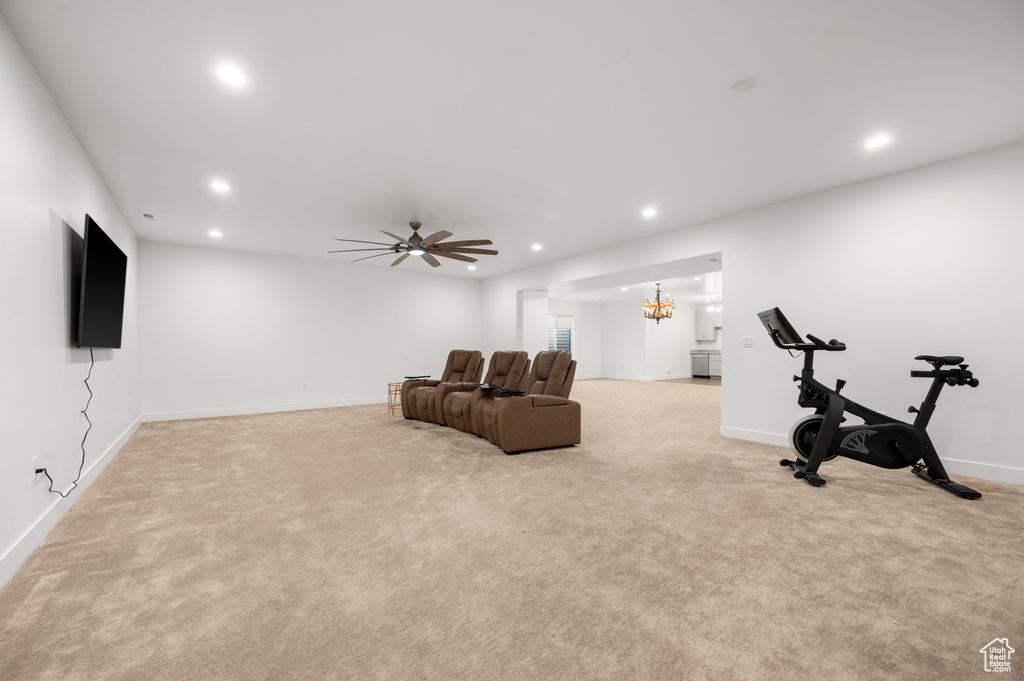 Interior space featuring light carpet and ceiling fan with notable chandelier