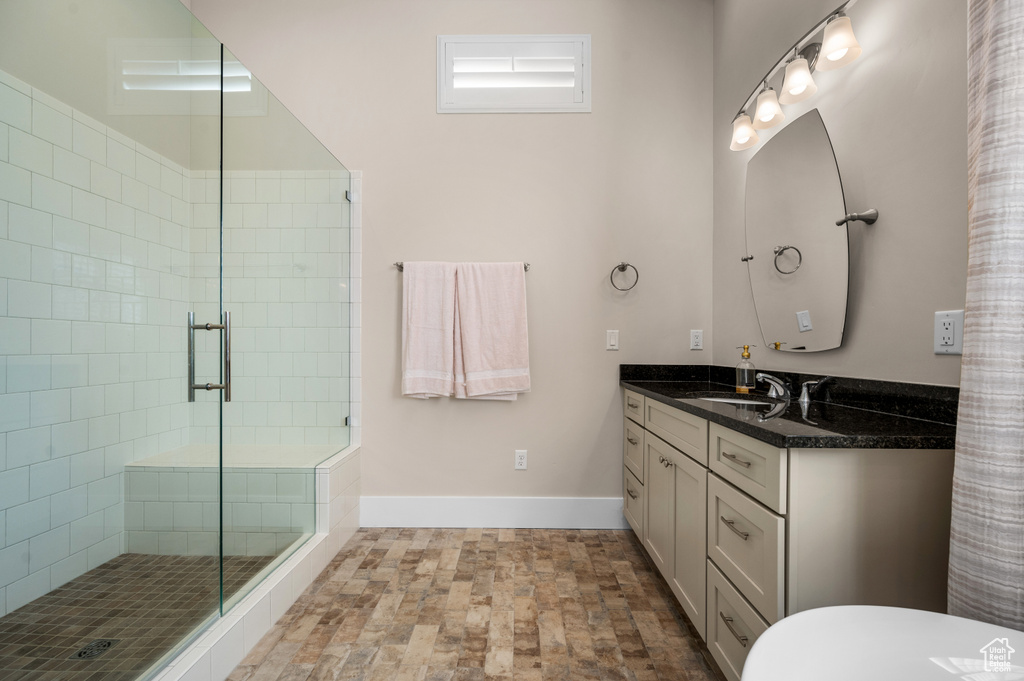 Bathroom with vanity with extensive cabinet space, tile flooring, and walk in shower