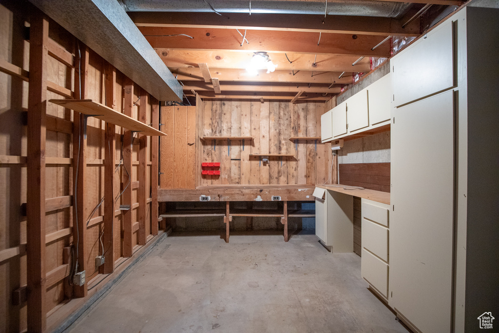 Basement with wooden walls and a workshop area