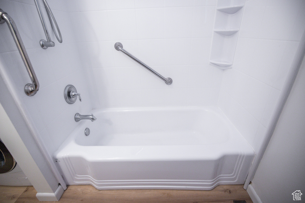 Bathroom featuring tiled shower / bath combo and hardwood / wood-style flooring