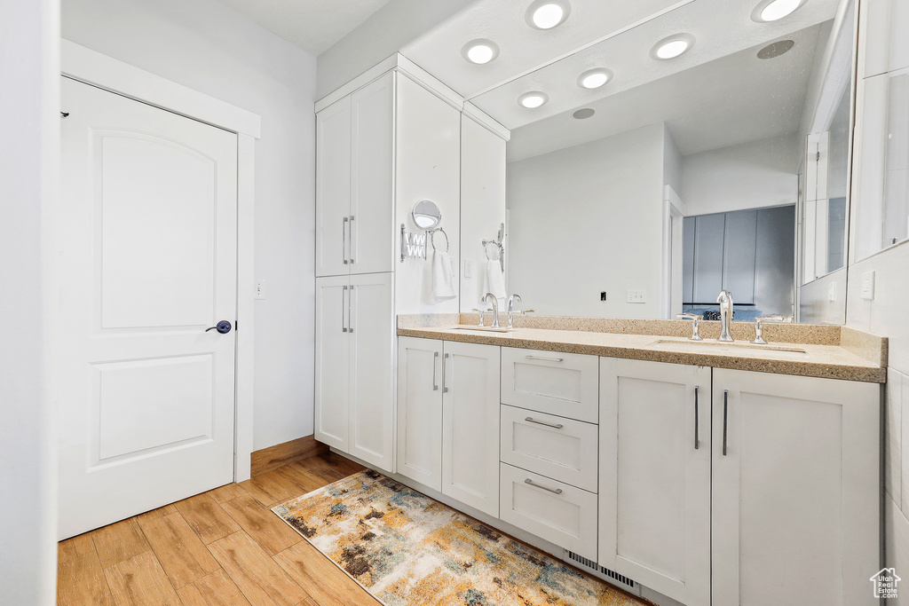 Bathroom with double vanity and hardwood / wood-style floors