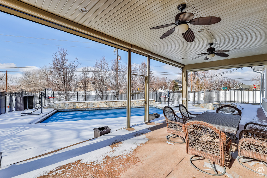 Exterior space with a fenced in pool and ceiling fan