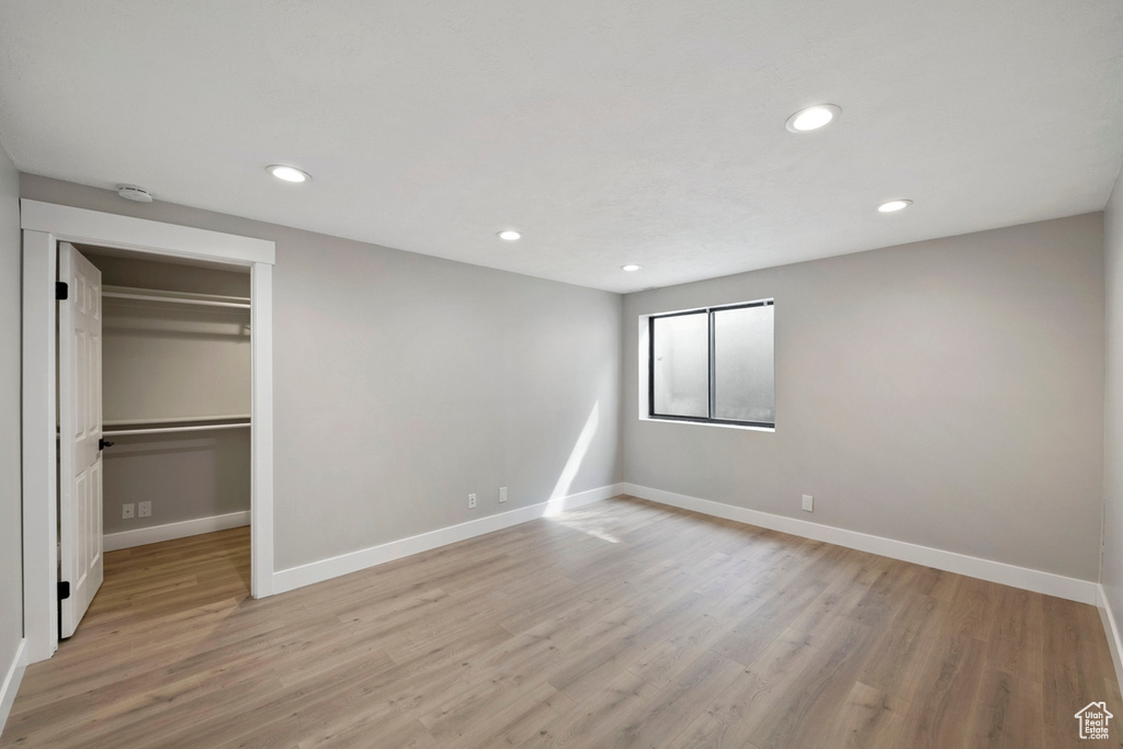 Unfurnished bedroom featuring a closet, a spacious closet, and light hardwood / wood-style floors