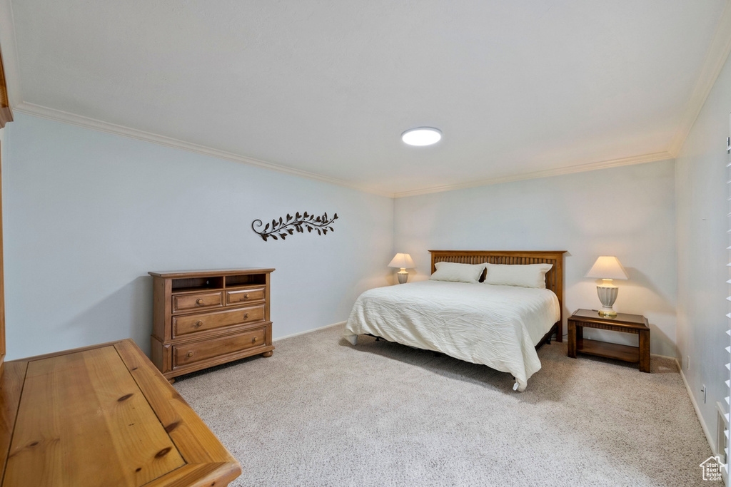 Carpeted bedroom with ornamental molding
