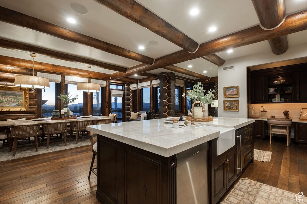 Kitchen with light stone countertops, a kitchen island with sink, decorative light fixtures, dark hardwood / wood-style floors, and dishwasher