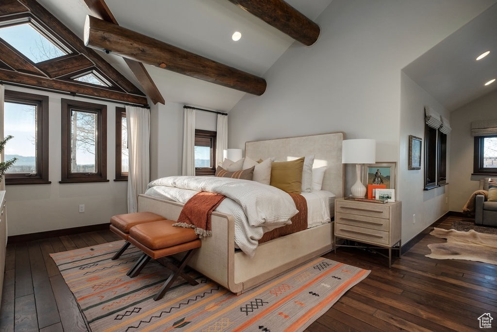 Bedroom featuring multiple windows, lofted ceiling with beams, and dark hardwood / wood-style floors