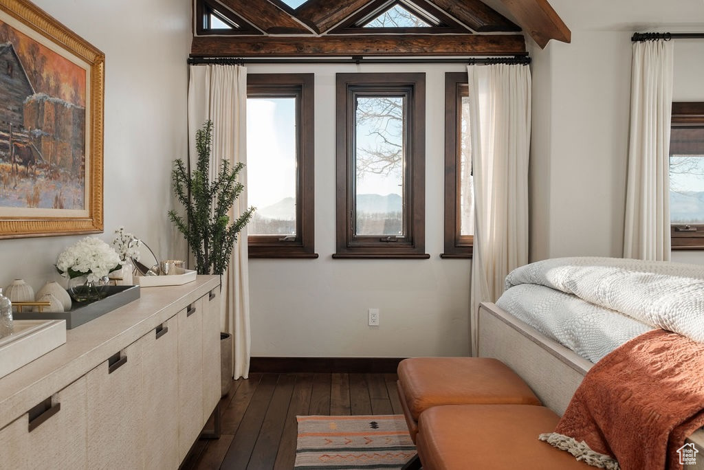 Bedroom with beam ceiling and dark hardwood / wood-style floors