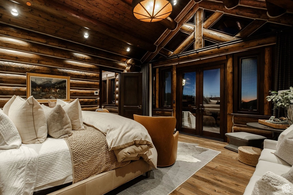 Bedroom with log walls, french doors, access to exterior, lofted ceiling with beams, and light wood-type flooring