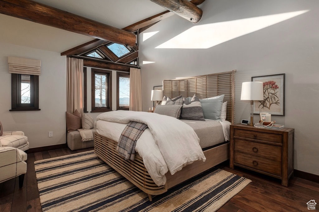 Bedroom with dark hardwood / wood-style flooring and vaulted ceiling with skylight