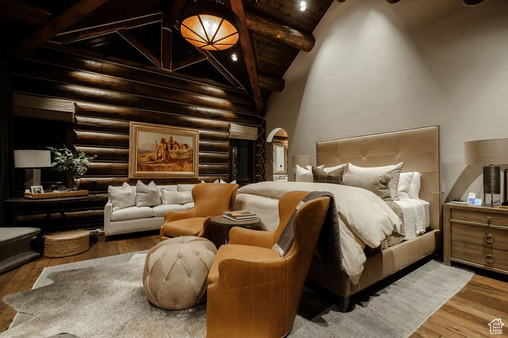 Bedroom with dark wood-type flooring, log walls, high vaulted ceiling, and beam ceiling