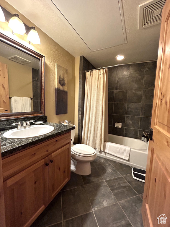 Full bathroom with toilet, tile floors, shower / tub combo with curtain, and vanity