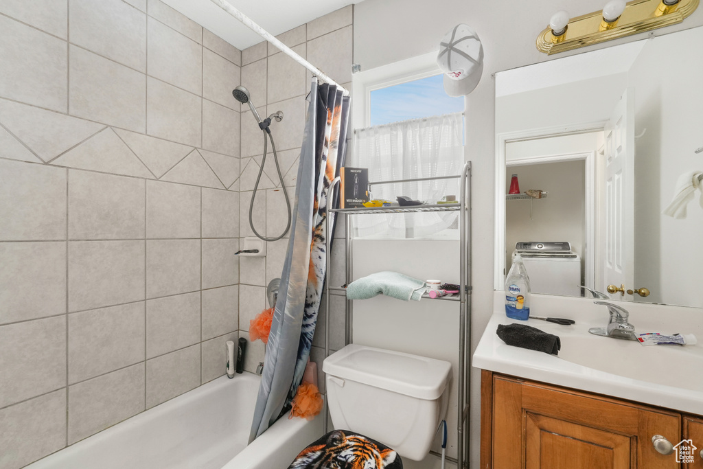 Full bathroom featuring washer / dryer, oversized vanity, toilet, and shower / bath combo