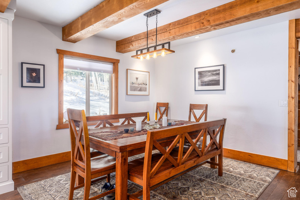 Dining room with beam ceiling and dark hardwood / wood-style flooring