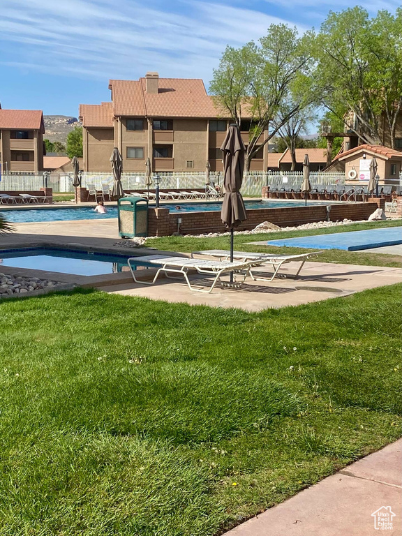 View of property\'s community featuring a yard and a pool