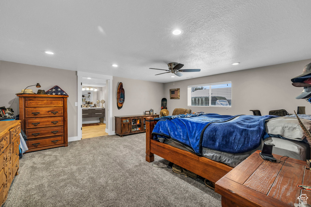 Bedroom with connected bathroom, light colored carpet, a textured ceiling, and ceiling fan