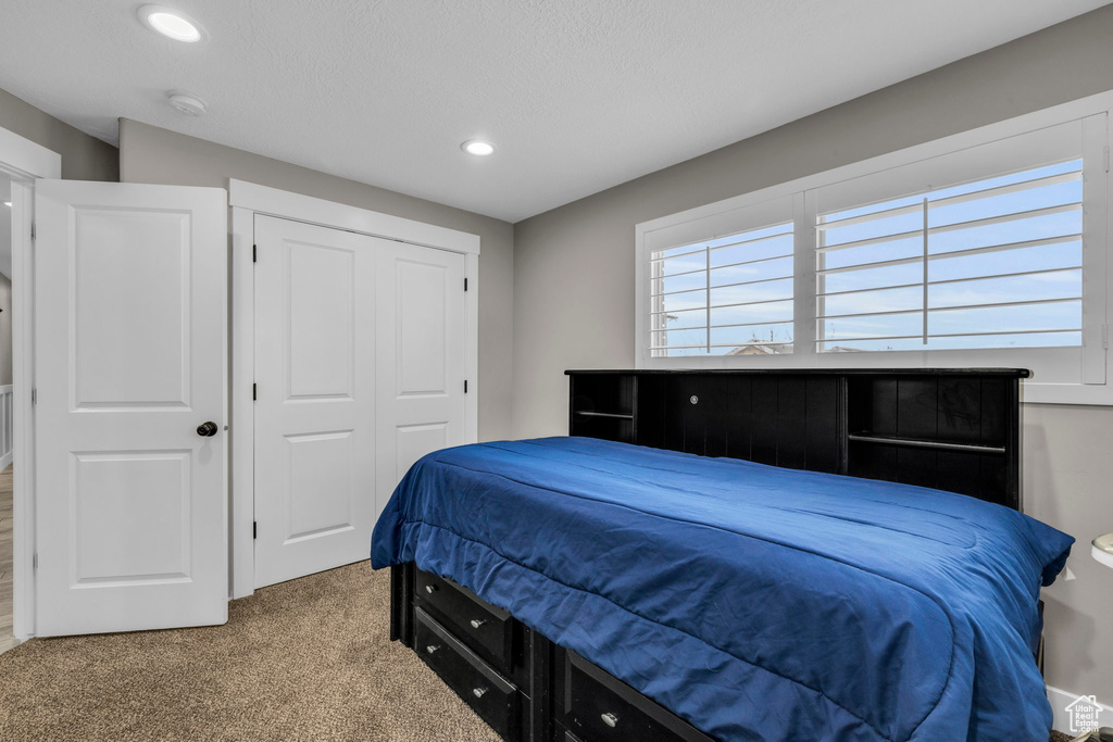 Bedroom with a closet and dark colored carpet