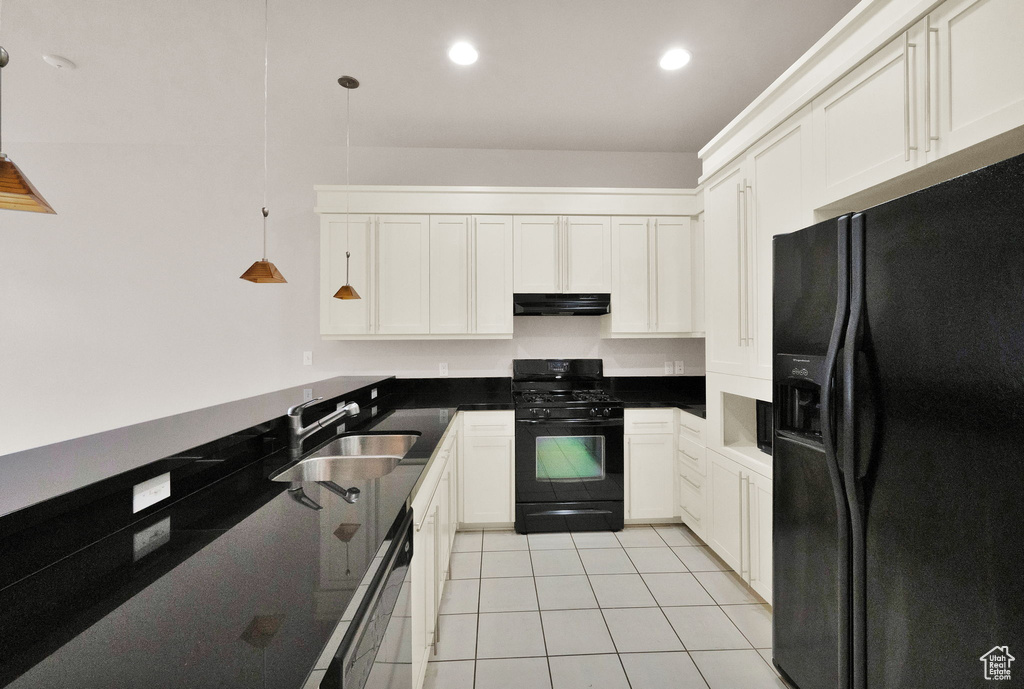 Kitchen with light tile flooring, black appliances, hanging light fixtures, white cabinets, and sink
