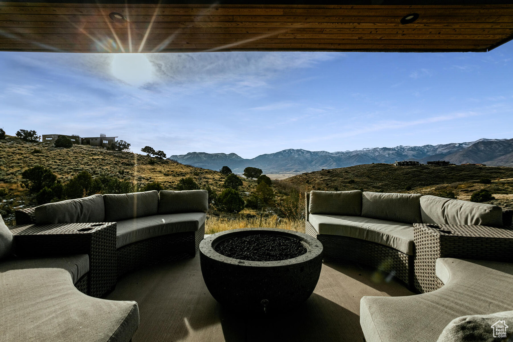 View of patio with an outdoor living space with a fire pit and a mountain view