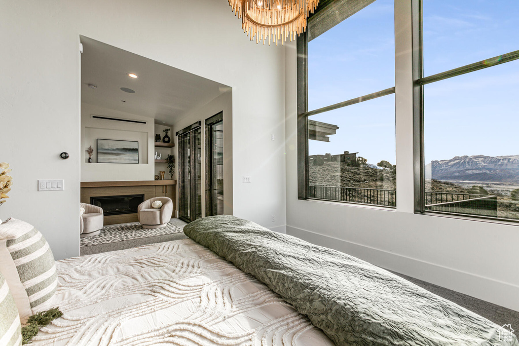 Bedroom featuring lofted ceiling, a mountain view, and light carpet