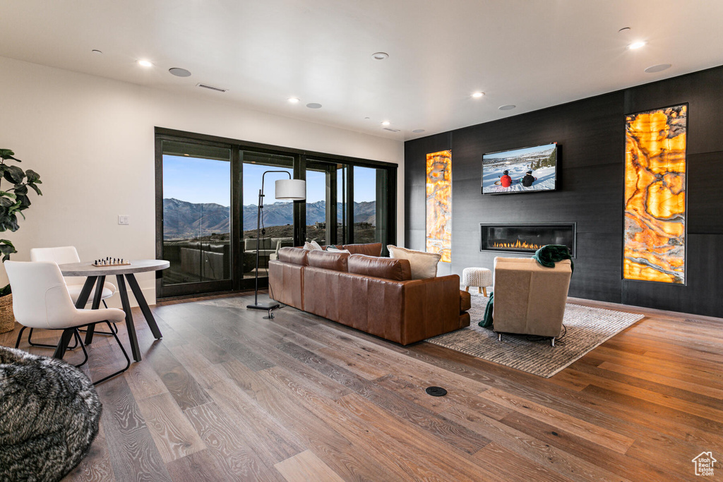 Living room with dark wood-type flooring, a large fireplace, and a mountain view