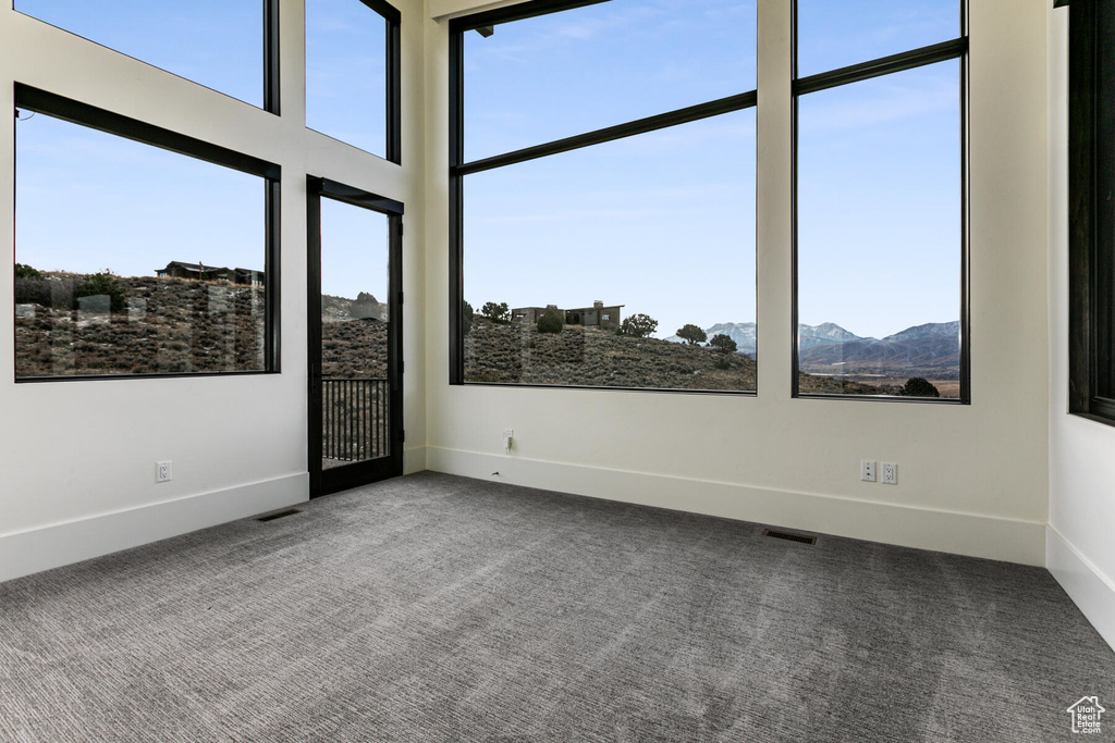 Carpeted empty room featuring a mountain view