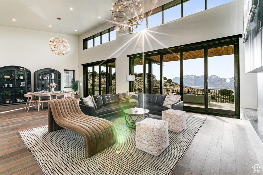 Living room featuring a chandelier, a high ceiling, a mountain view, and light hardwood / wood-style flooring