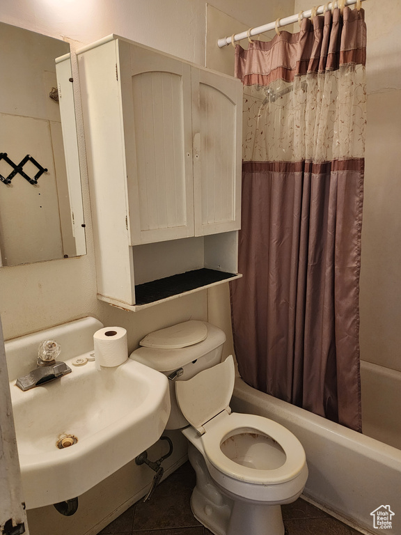 Full bathroom with sink, shower / tub combo with curtain, toilet, and tile flooring