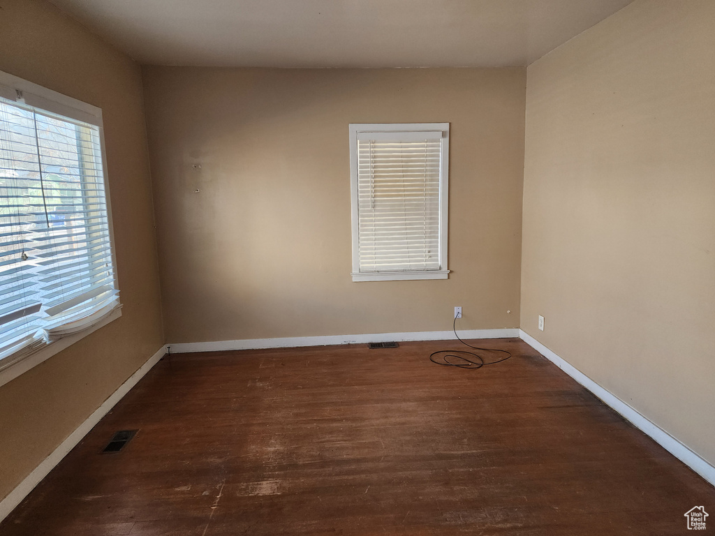Empty room featuring dark hardwood / wood-style flooring