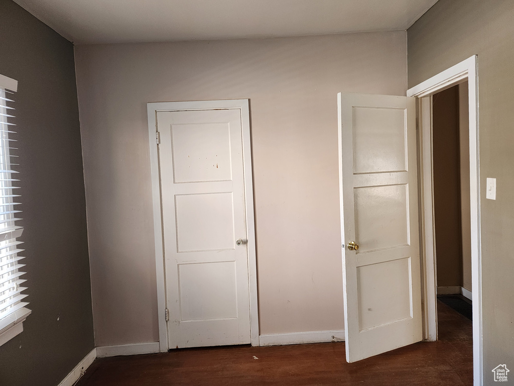 Unfurnished bedroom with dark hardwood / wood-style floors