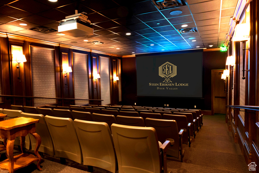 Home theater featuring a paneled ceiling, indoor bar, and dark colored carpet