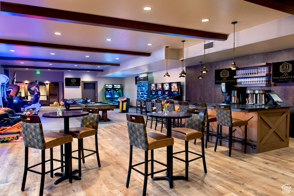 Bar featuring beam ceiling, light wood-type flooring, hanging light fixtures, and pool table