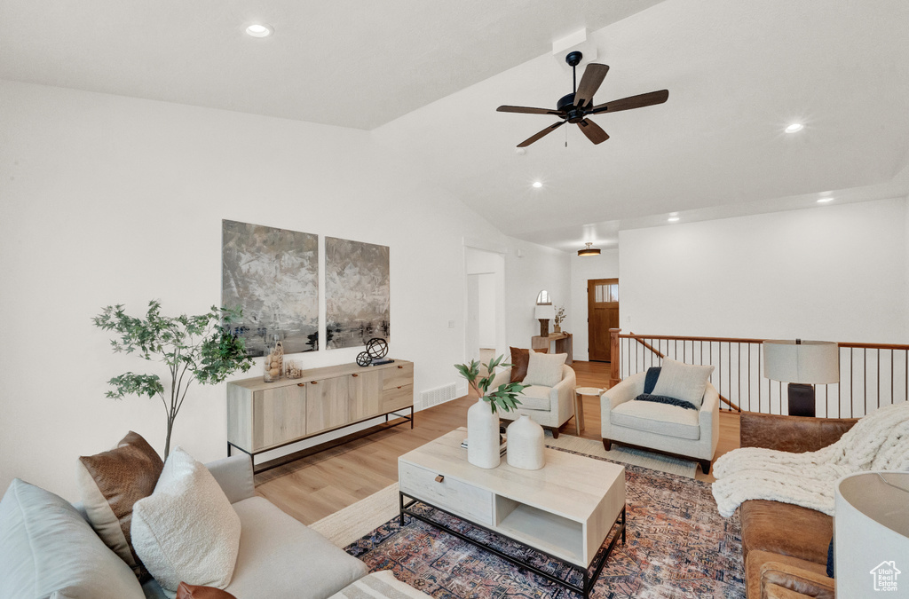 Living room featuring lofted ceiling, light hardwood / wood-style floors, and ceiling fan