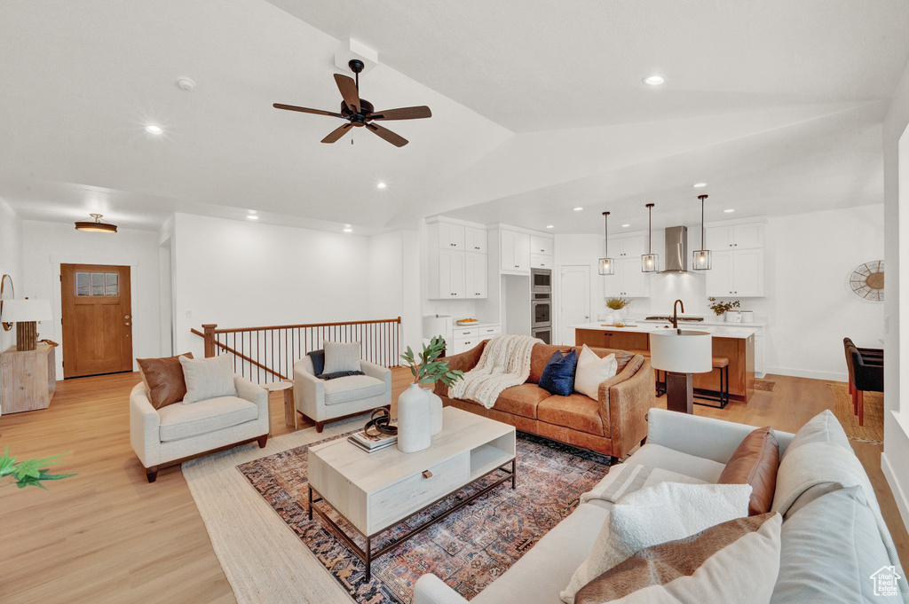 Living room with light hardwood / wood-style flooring, sink, lofted ceiling, and ceiling fan