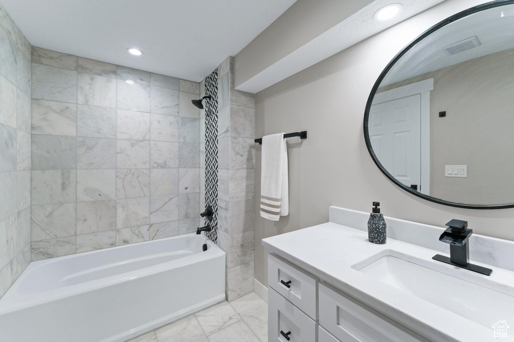 Bathroom featuring tile flooring, tiled shower / bath, and large vanity