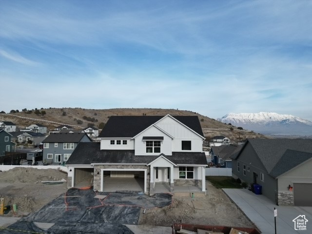 View of front of house with a garage, a mountain view, and a patio