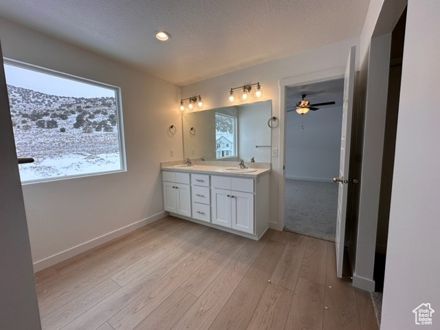 Bathroom featuring dual vanity, hardwood / wood-style flooring, and ceiling fan