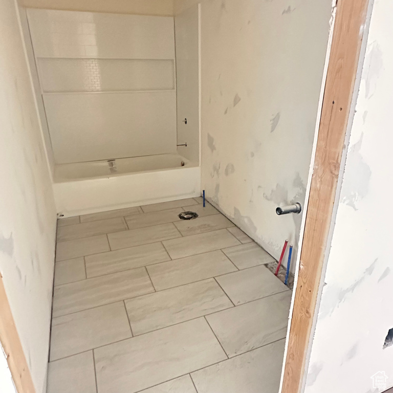 Bathroom with tile floors and washtub / shower combination