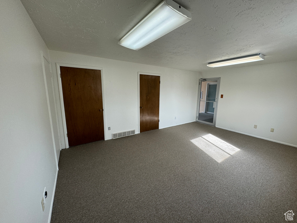 Unfurnished room featuring a textured ceiling and carpet flooring