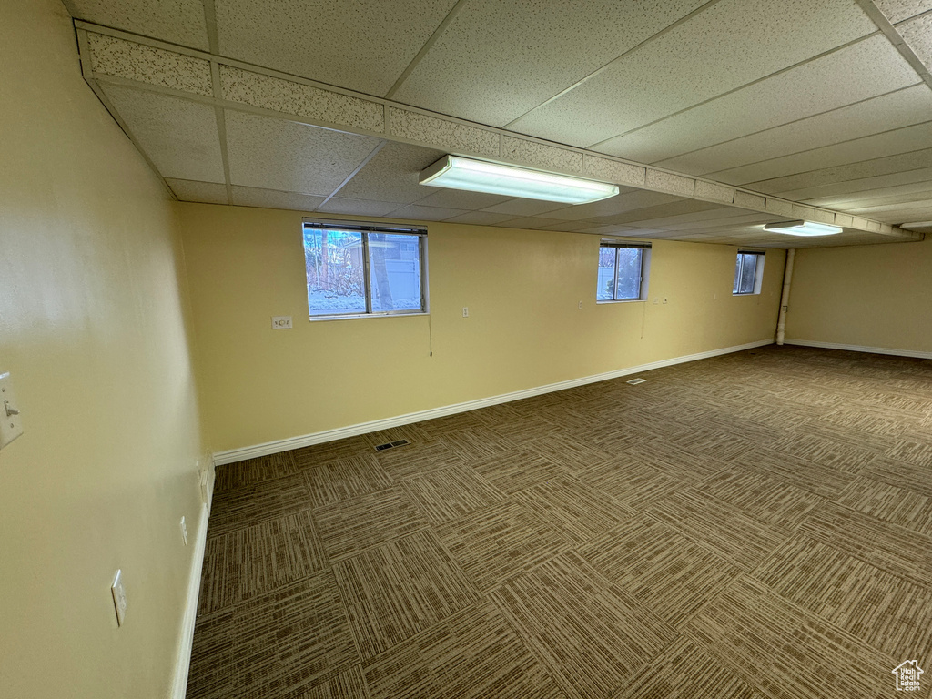 Unfurnished room featuring carpet and a paneled ceiling