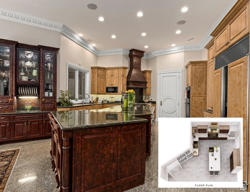 Kitchen with crown molding, dark stone counters, a center island, premium range hood, and light tile floors