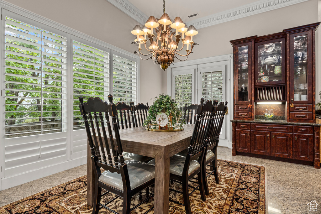 Tiled dining room with a notable chandelier and ornamental molding